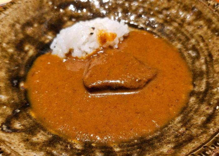 Japanese wagyu beef curry, served with a reserved portion of meat and rice for tasting.